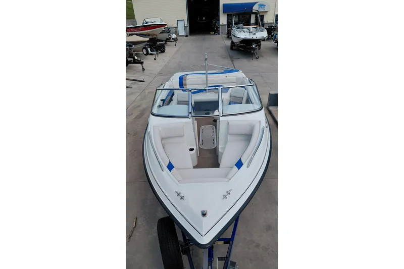 Slide: The Image of 1999 Ebbtide Campione 190 boat with white and blue interior, parked on a trailer. - 12