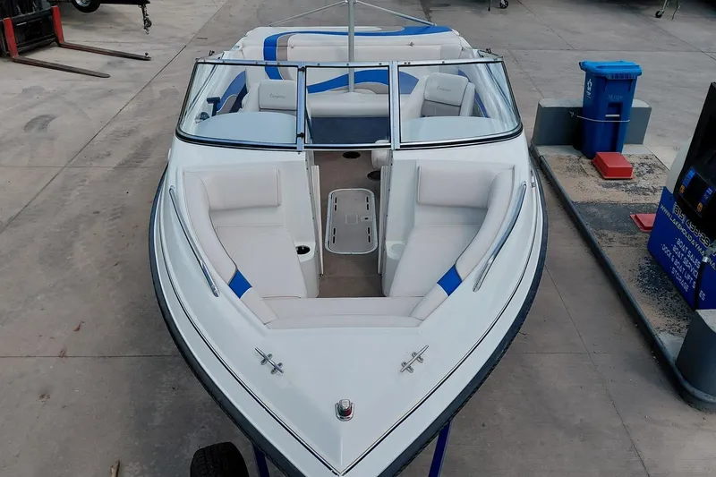 Slide: The Image of 1999 Ebbtide Campione 190 boat with white and blue interior, docked at a marina. - 11