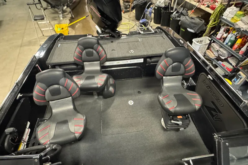 Slide: The Image of 2021 Nitro ZV19 Sport boat interior with four black and red seats in a garage setting. - 21