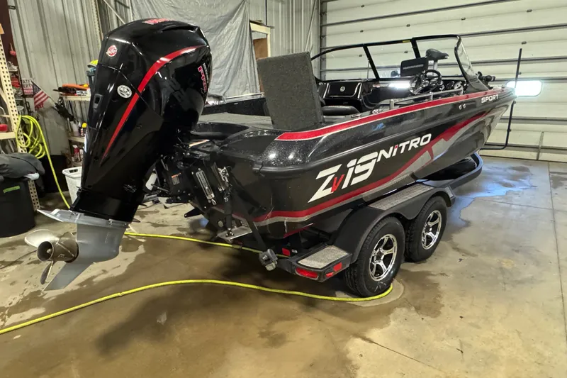 Slide: The Image of 2021 Nitro ZV19 Sport boat in a garage, featuring a powerful outboard motor. - 3