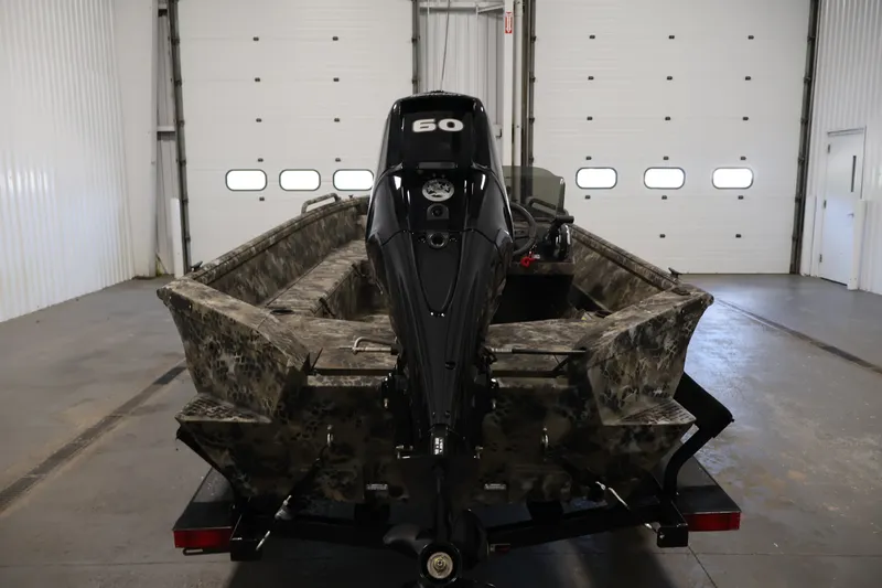 Slide: The Image of 2025 Excel 1651 River Warrior SC boat with camouflage design in a garage setting. - 6