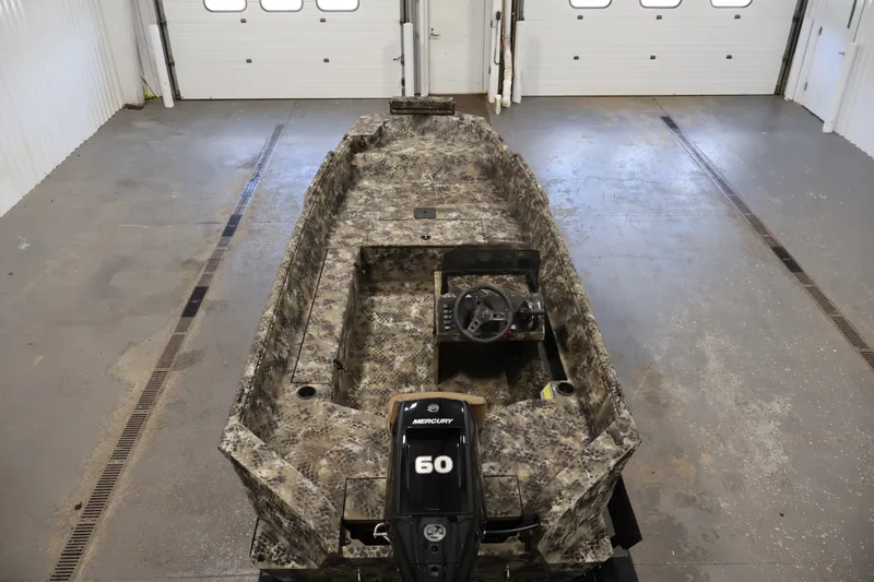 Slide: The Image of 2025 Excel 1651 River Warrior SC boat with camouflage design in a garage setting. - 10