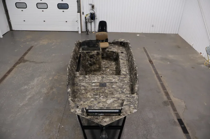 Slide: The Image of 2025 Excel 1651 River Warrior SC boat in a garage, featuring camouflage design. - 9
