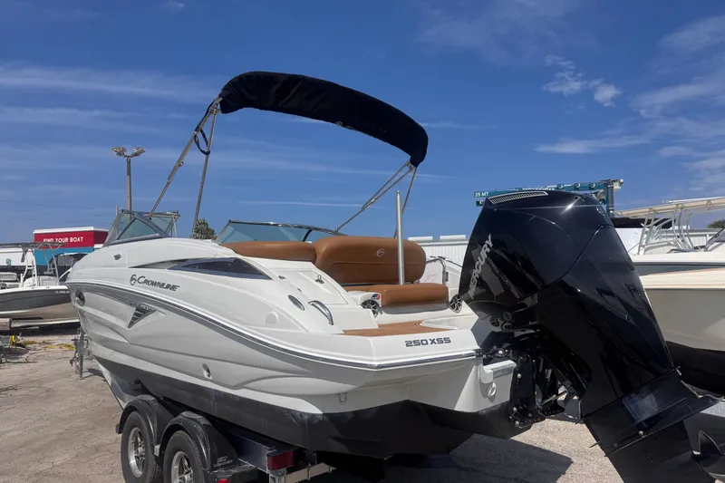 Slide: The Image of 2023 Crownline 250 XSS boat with Mercury outboard motor, parked on a trailer. - 3