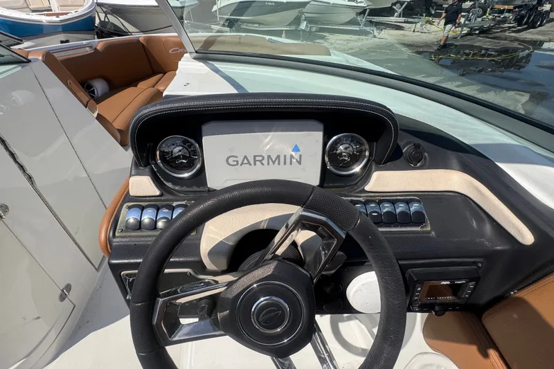 Slide: The Image of 2023 Crownline 250 XSS boat dashboard with Garmin navigation system and steering wheel. - 8