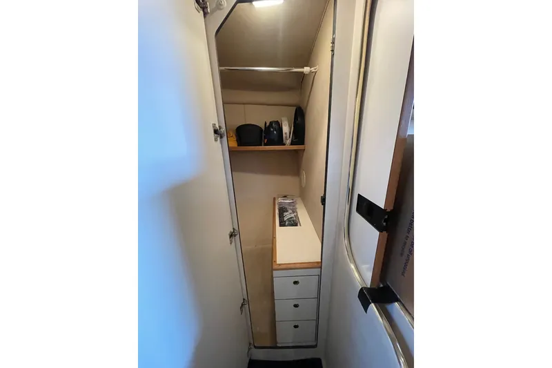 Slide: The Image of 1999 Sea Ray 370 Express Cruiser interior storage with shelves and drawers. - 25