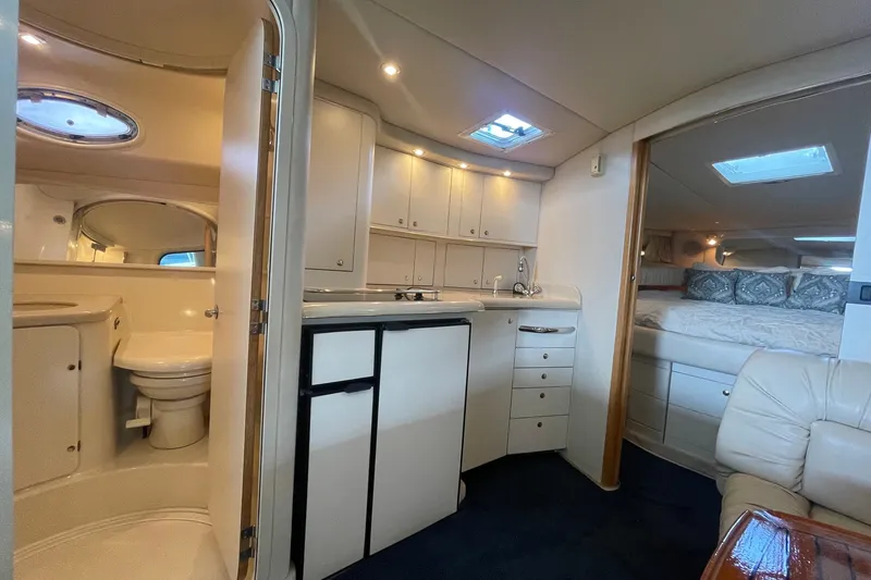 Slide: The Image of Interior of 1999 Sea Ray 370 Express Cruiser with kitchenette, bathroom, and cozy sleeping area. - 15