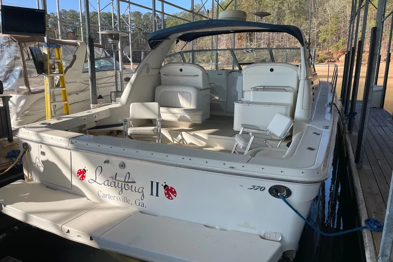 Slide: The Image of 1999 Sea Ray 370 Express Cruiser docked, featuring spacious seating and "Ladybug II" name. - 27