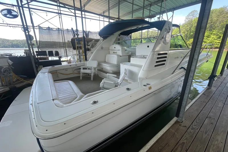 Slide: The Image of 1999 Sea Ray 370 Express Cruiser docked, featuring spacious seating and sleek design. - 32