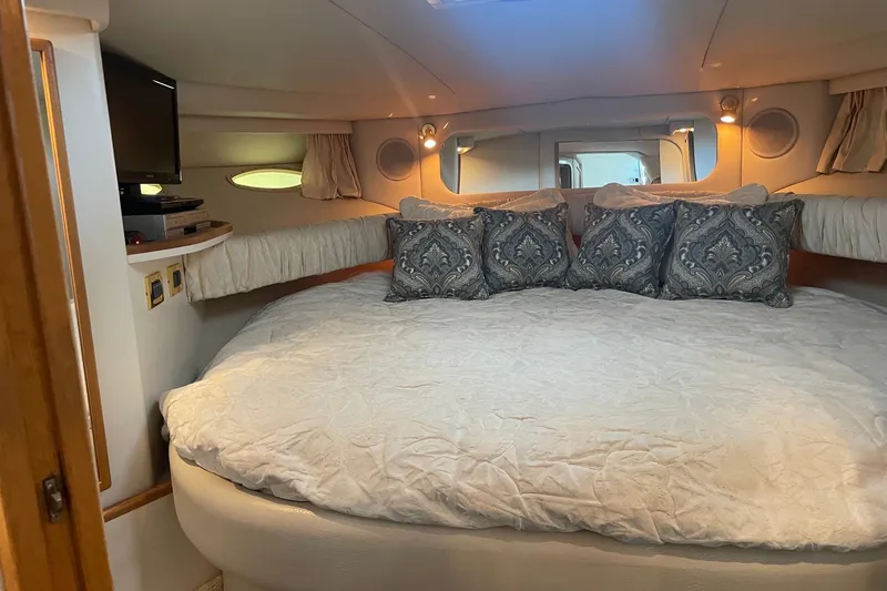 Slide: The Image of Luxurious cabin interior of a 1999 Sea Ray 370 Express Cruiser with elegant bedding. - 20