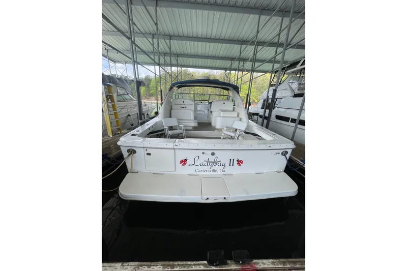 Slide: The Image of 1999 Sea Ray 370 Express Cruiser docked in covered marina, rear view. - 28