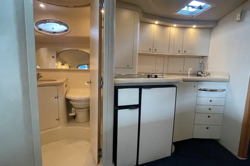 Slide: The Image of 1999 Sea Ray 370 Express Cruiser interior with kitchenette and bathroom. - 16