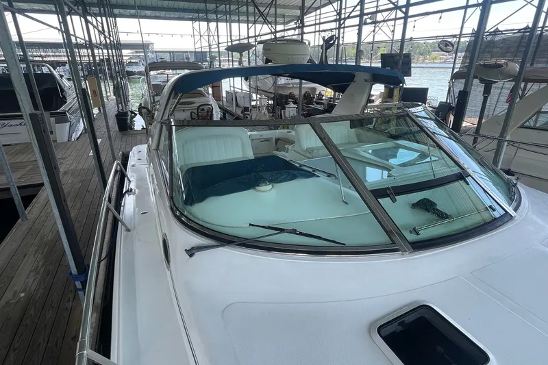 Slide: The Image of 1999 Sea Ray 370 Express Cruiser docked in a marina, under a covered structure. - 29