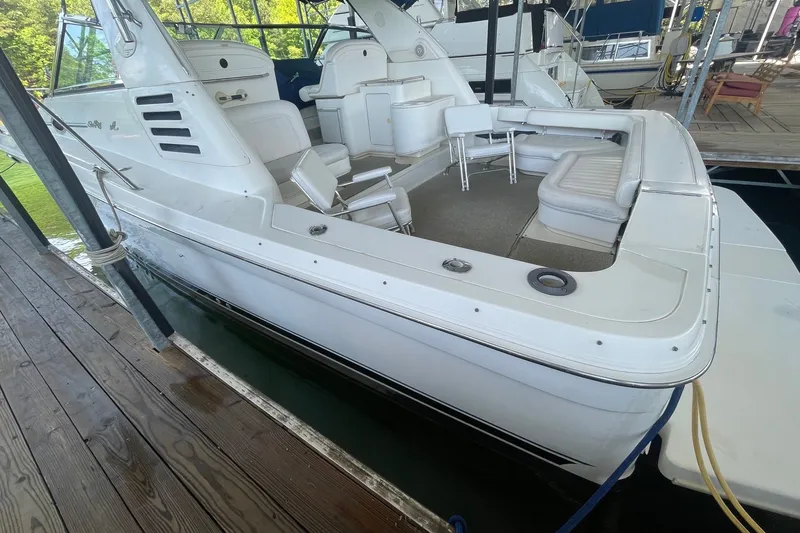 Slide: The Image of 1999 Sea Ray 370 Express Cruiser docked, featuring spacious seating and sleek white design. - 30