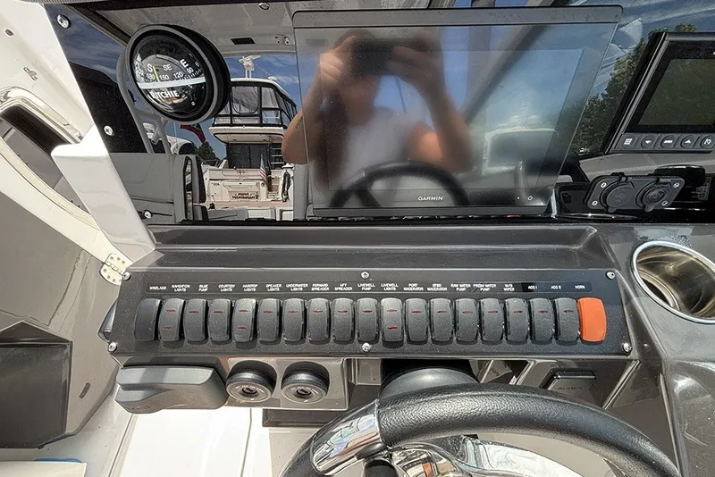 Slide: The Image of 2023 Blackfin 272 DC dashboard with Garmin display and control switches. - 17