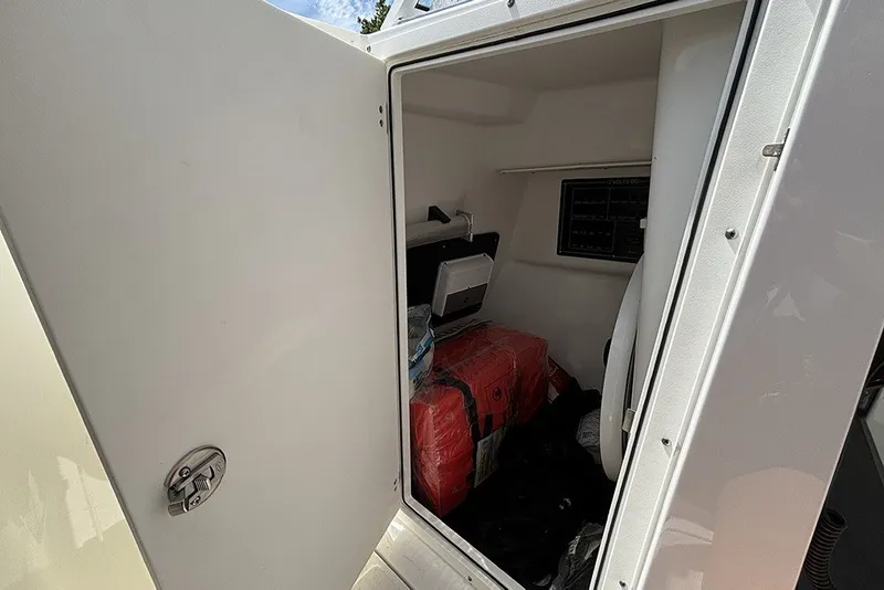 Slide: The Image of Storage compartment inside 2023 Blackfin 272 DC boat, featuring organized equipment and supplies. - 23