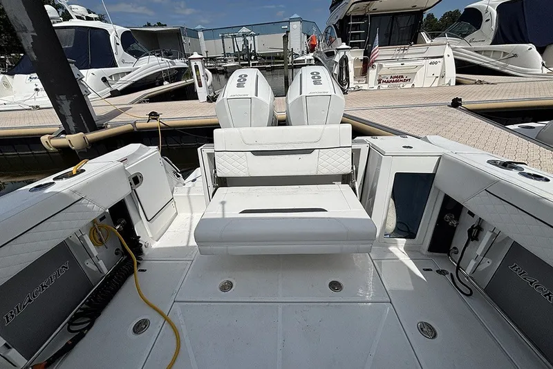 Slide: The Image of 2023 Blackfin 272 DC boat interior at marina, featuring dual engines and seating area. - 7