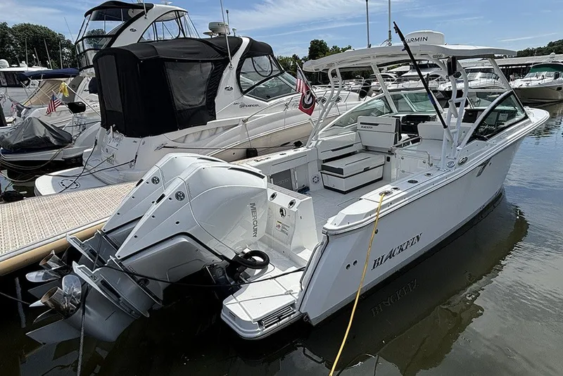 Slide: The Image of 2023 Blackfin 272 DC boat docked, featuring dual Mercury outboard engines. - 3