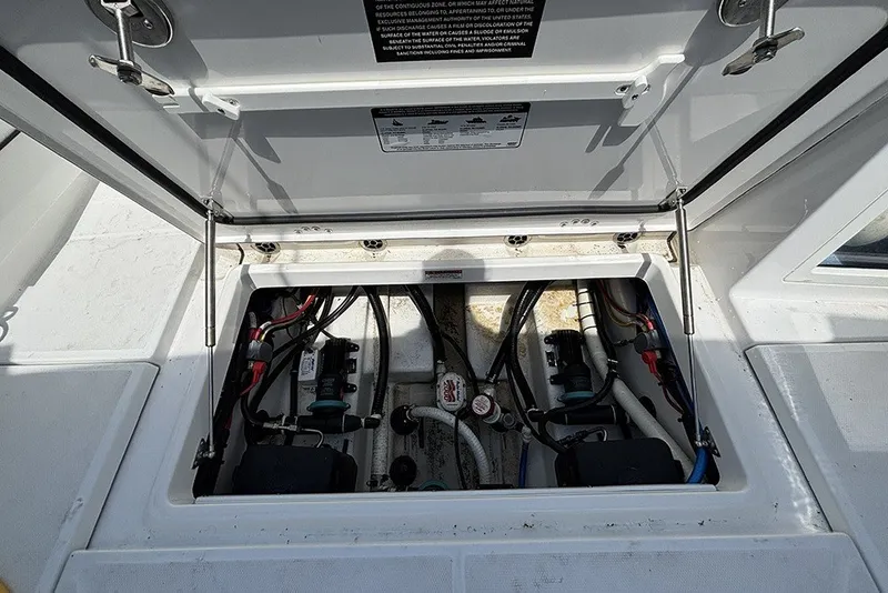 Slide: The Image of Open hatch of 2023 Blackfin 272 DC boat showing internal wiring and components. - 32