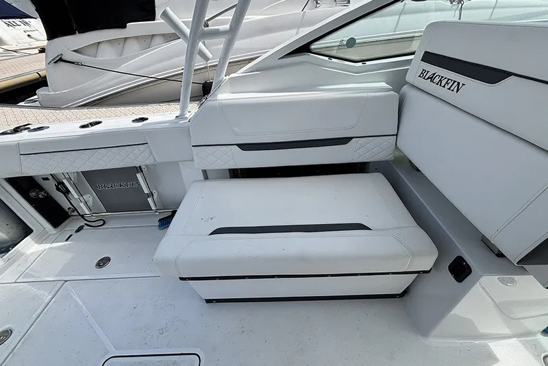 Slide: The Image of 2023 Blackfin 272 DC boat interior with white seating and storage compartments. - 13