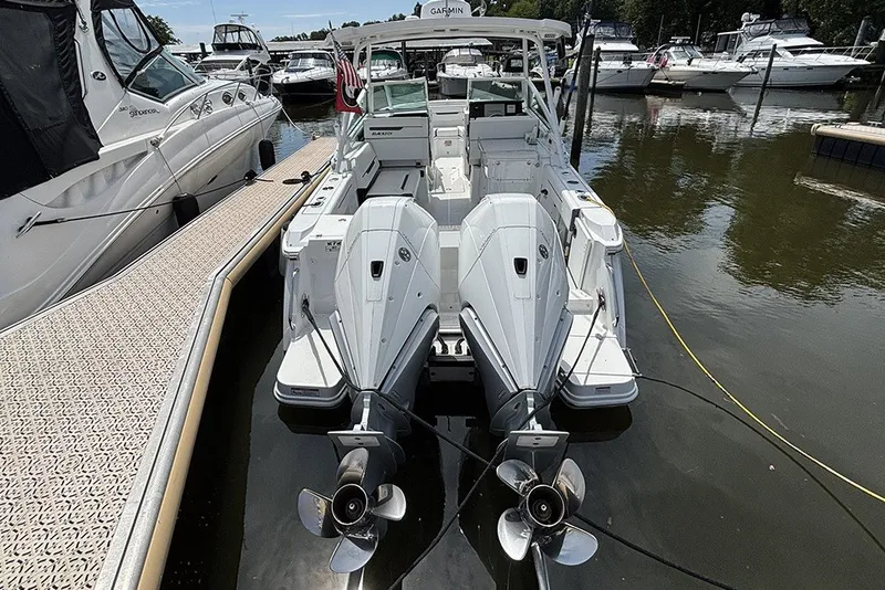 Slide: The Image of 2023 Blackfin 272 DC boat docked with dual outboard engines in a marina. - 2