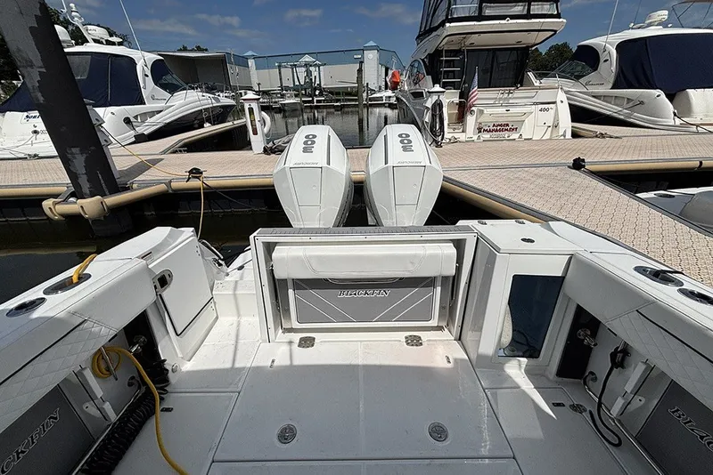 Slide: The Image of 2023 Blackfin 272 DC boat docked with twin outboard engines in a marina. - 6