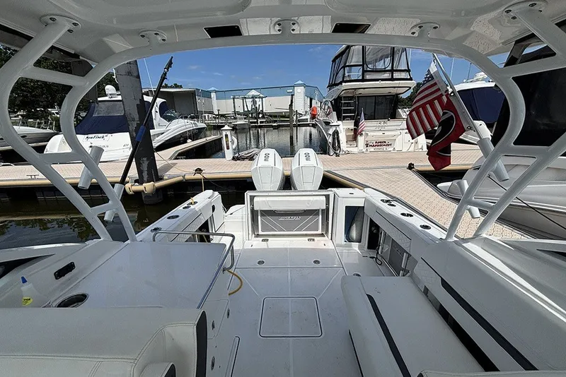 Slide: The Image of 2023 Blackfin 272 DC boat interior at marina, showcasing seating and docked vessels. - 14