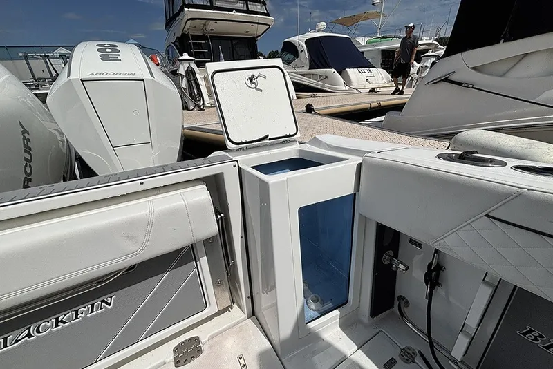 Slide: The Image of 2023 Blackfin 272 DC boat interior with open storage compartment and Mercury engines. - 8