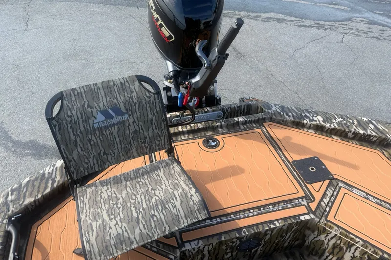 Slide: The Image of 2027 Avid 18 Commander boat with camo seat and motor, on textured deck. - 18