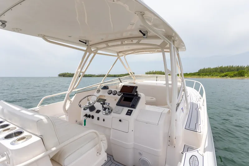 Slide: The Image of 2006 Intrepid 348 Walkaround boat interior with steering console, ocean view, and lush shoreline. - 28