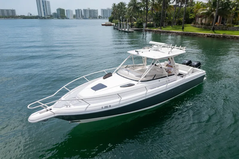 Slide: The Image of 2006 Intrepid 348 Walkaround boat cruising on a scenic waterfront with city skyline. - 5