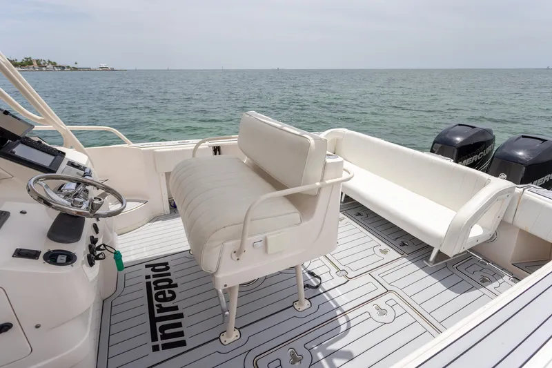 Slide: The Image of 2006 Intrepid 348 Walkaround boat interior with seating and steering wheel, overlooking the ocean. - 31