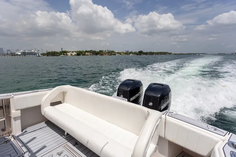 Slide: The Image of 2006 Intrepid 348 Walkaround boat cruising with twin Mercury engines on a sunny day. - 29