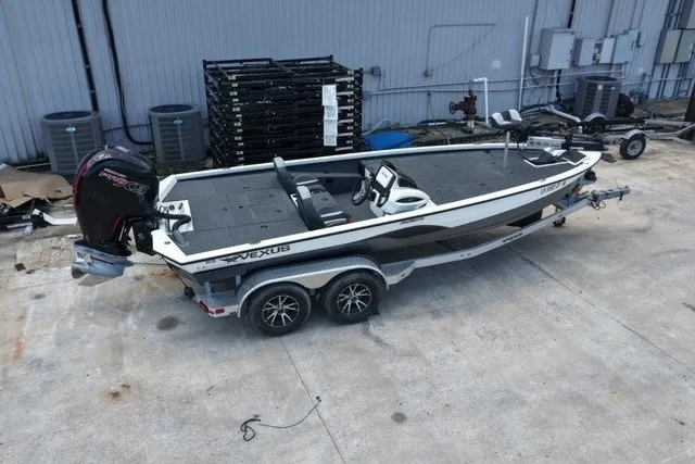 Slide: The Image of 2023 Vexus AVX1980 boat on trailer, parked outdoors near industrial building. - 7