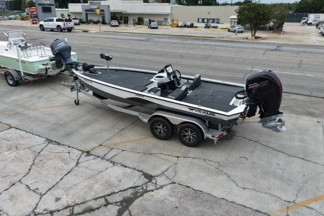 Slide: The Image of 2023 Vexus AVX1980 boat on trailer in parking lot, showcasing sleek design and dual motors. - 10