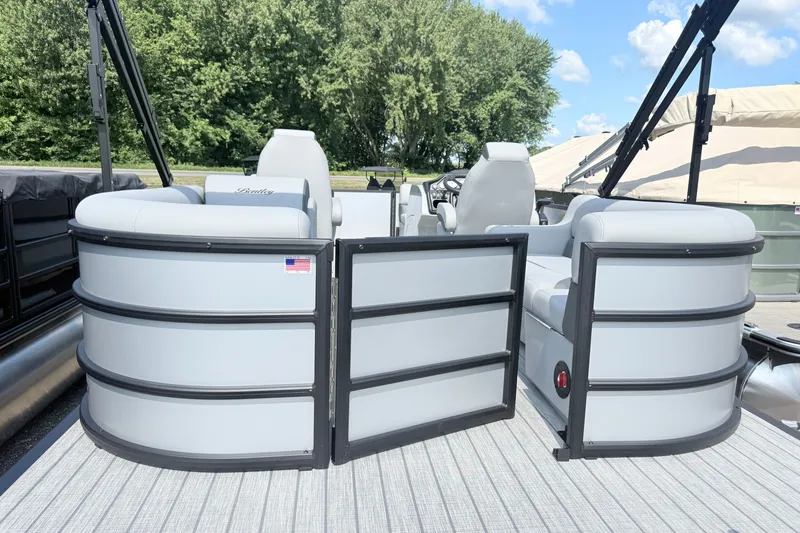 Slide: The Image of 2027 Bentley Pontoons Legacy 200 Navigator, sleek design, open gate, luxurious seating, outdoor setting. - 2
