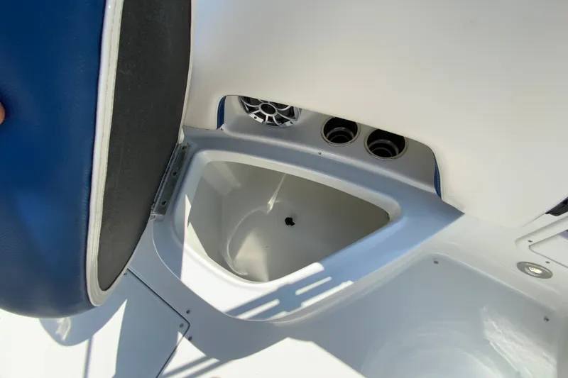 Slide: The Image of 2019 Crownline Eclipse E235 XS boat storage compartment with blue seat and cup holders. - 26