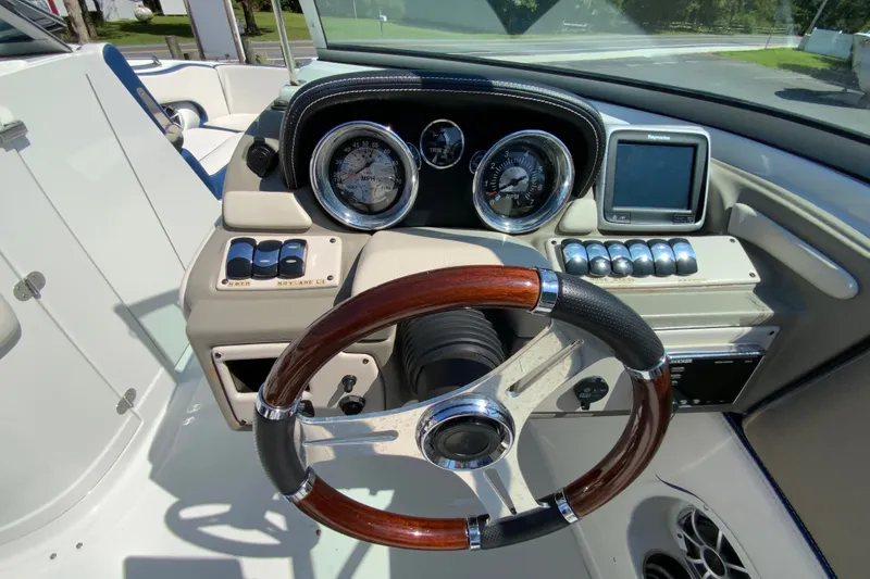 Slide: The Image of 2019 Crownline Eclipse E235 XS boat dashboard with gauges, controls, and wooden steering wheel. - 15