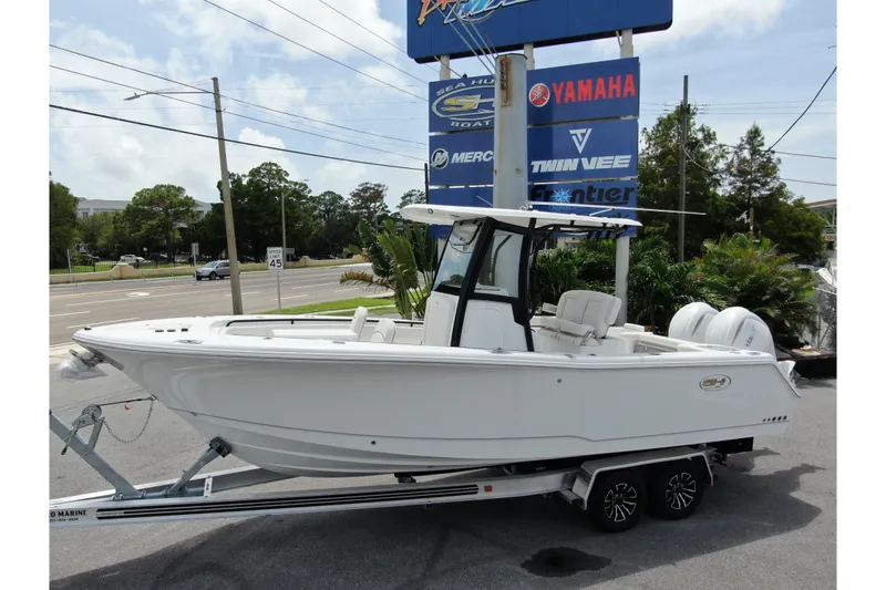 The Image of 2027 Sea Hunt Gamefish 25 boat on trailer, displayed at dealership with Yamaha signage. - 0