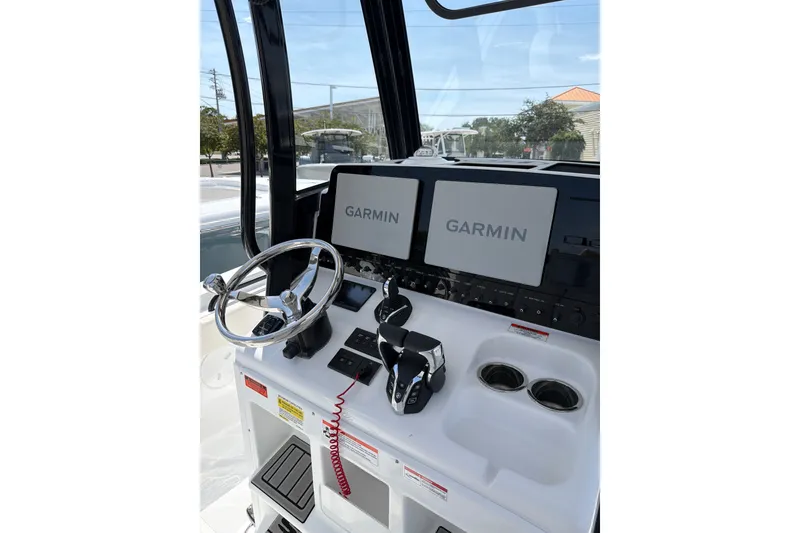 Slide: The Image of 2027 Sea Hunt Gamefish 25 dashboard with Garmin displays and steering wheel. - 24