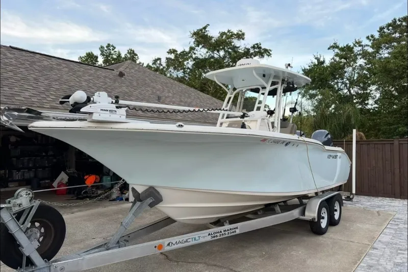 Slide: The Image of 2024 Key West 244 Center Console boat on trailer, parked in driveway. - 0