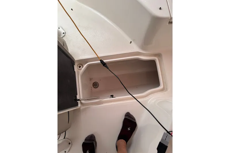 Slide: The Image of 2023 Key West 244 Center Console boat interior with storage compartment and wiring. - 10