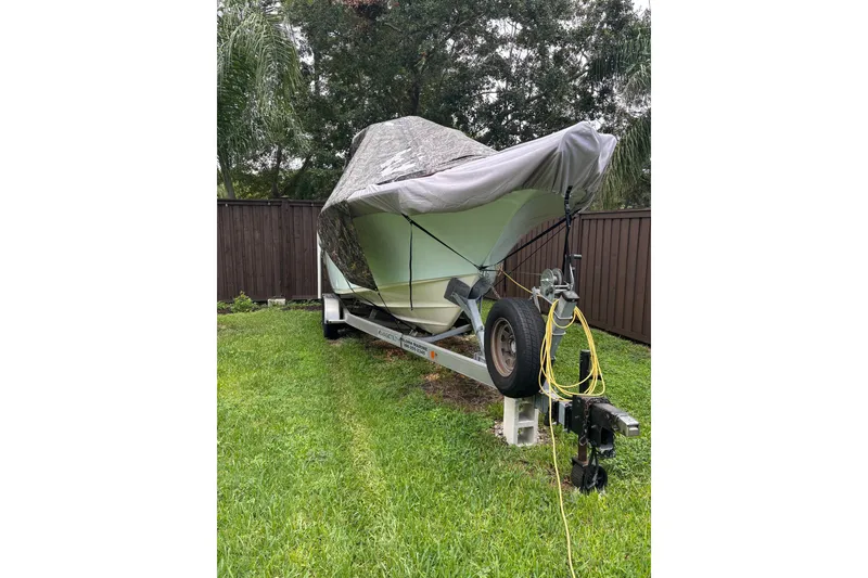 Slide: The Image of Covered 2023 Key West 244 Center Console boat on trailer in grassy yard. - 3