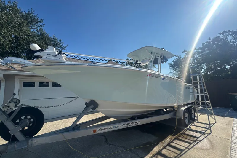 Slide: The Image of 2023 Key West 244 Center Console boat on trailer under clear blue sky. - 4
