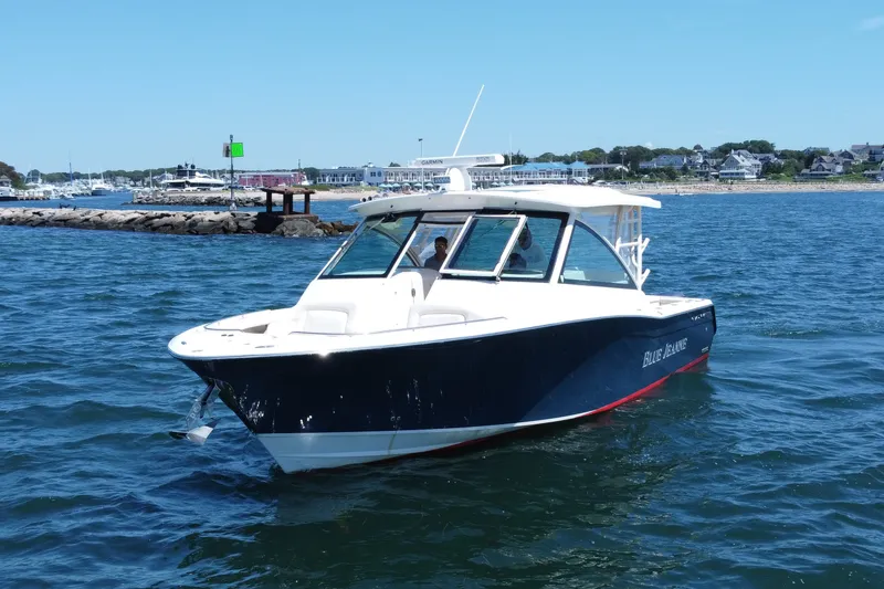 Slide: The Image of 2015 Grady-White Freedom 375 boat cruising near a rocky shoreline. - 3