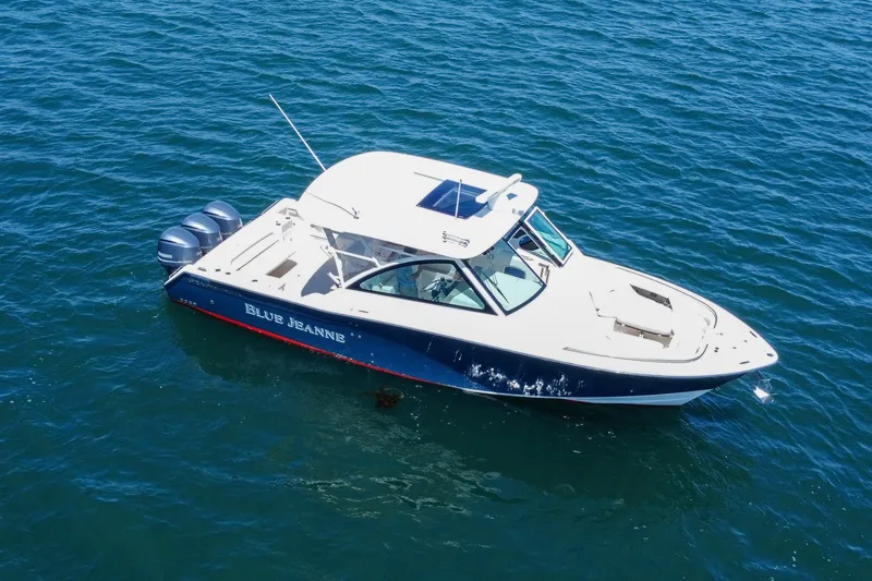 Slide: The Image of 2015 Grady-White Freedom 375 boat on open water, featuring triple outboard engines. - 13