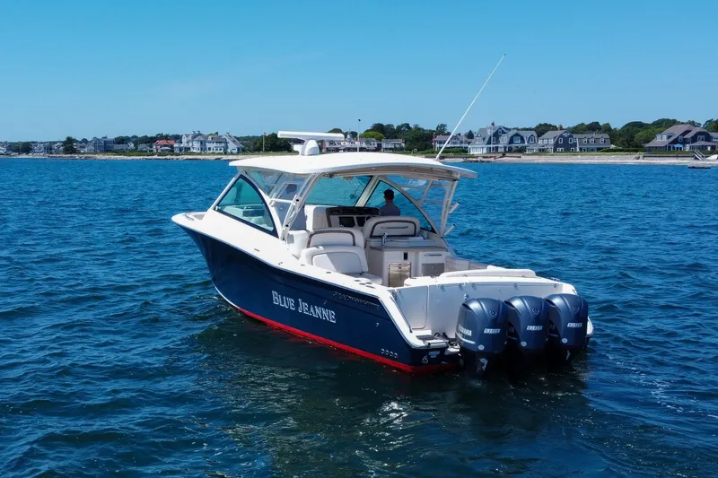 Slide: The Image of 2015 Grady-White Freedom 375 boat on water, with coastal homes in the background. - 6