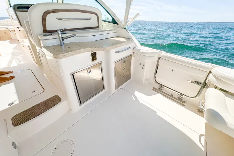 Slide: The Image of 2015 Grady-White Freedom 375 boat interior with kitchenette, ocean view, and seating area. - 40
