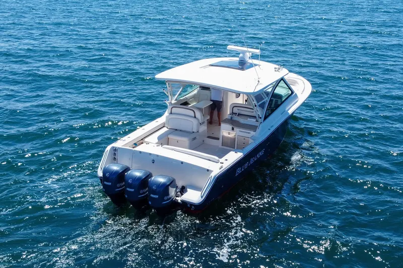 Slide: The Image of 2015 Grady-White Freedom 375 boat cruising on open water with triple Yamaha engines. - 8