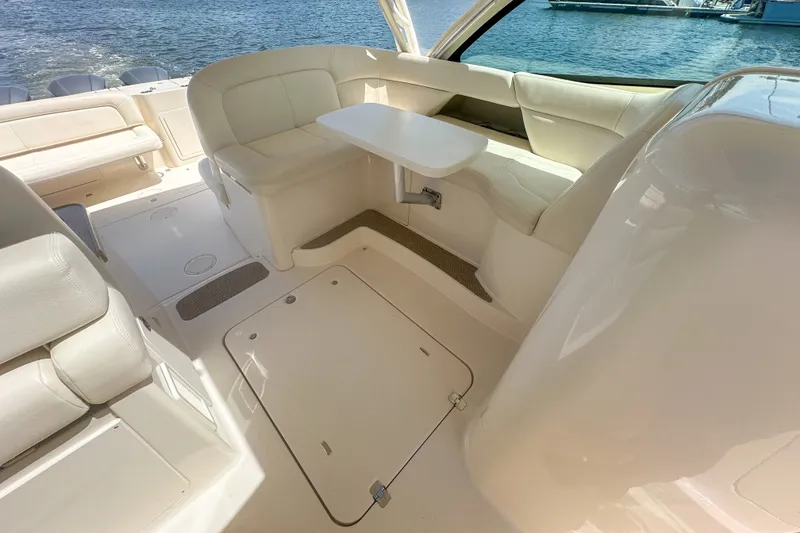 Slide: The Image of 2015 Grady-White Freedom 375 boat interior with seating and table, docked by the water. - 23